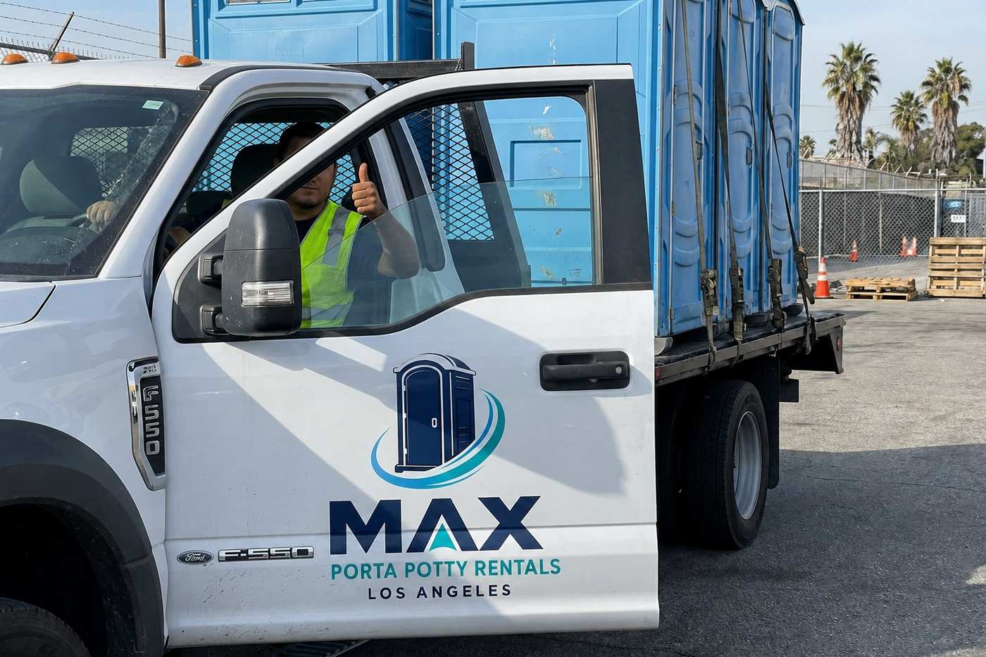 Branded Max Porta Potty Rentals Los Angeles delivery truck with driver giving thumbs up