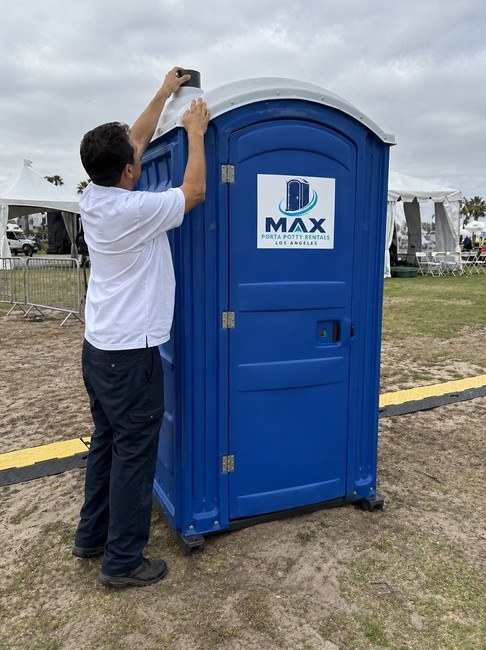 Technician setting up a portable restroom